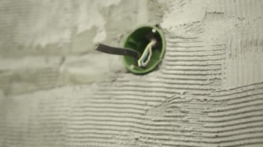 Beton bir duvardaki çıkıntılı kablolar için dahili soket.