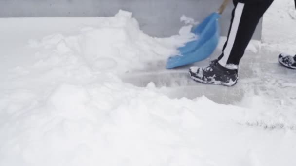 Kiev, Ukraine - 9 février 2021 : Jeter de la neige d'une passerelle en béton autour d'une maison au ralenti — Video