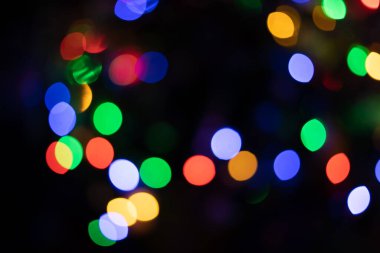 Koyu arkaplandaki renkli ışıkların güzel yaratıcı bokeh 'i