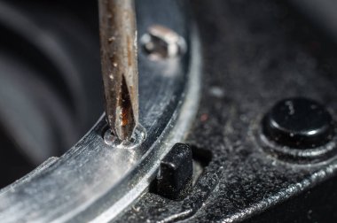 Phillips tornavidayı söker. Kameranın demir kısmını yakın plan monte eder..