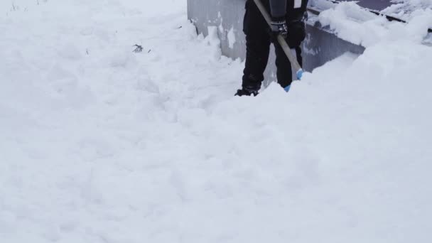 Kiev, Ukraine - February 9, 2021: Throwing snow from the foundation of the house to avoid flooding the basement in the spring — Stock Video