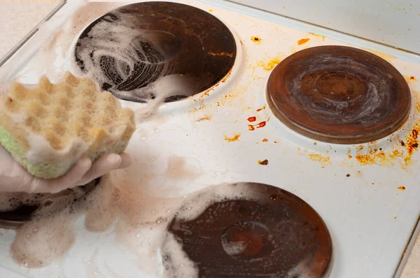 Kirli bir elektrikli sobanın, deterjan kullanmadan önce ve sonra çekilmiş fotoğrafı ve ovmak için sünger.