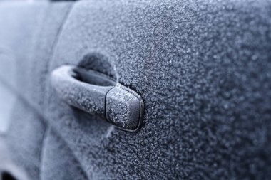 Arabadaki kapı açacağı kışın ortasında donla kaplıdır.