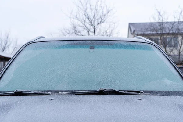 Kış sabahı buz ve buzla kaplı soğuk ısırığı ön camı.