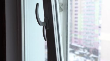 Kiev, Ukrayna - 27 Şubat 2021: Dairedeki plastik pencereyi havalandırdıktan sonra kapatmak