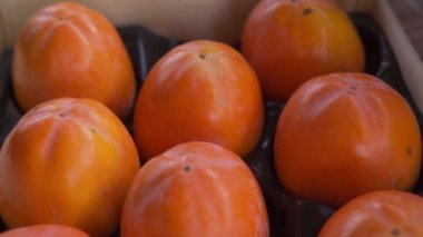 Canlı turuncu hurmalarla dolu bir kutunun üzerinden uç.