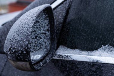 Arabanın dış dikiz aynası kışın buzla kaplıdır.