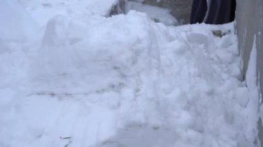 Akşamları bir kürekle büyük bir kar yığını fırlatıyor.