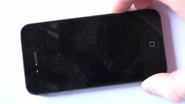 Kijów, Ukraina - 11 marca 2021: stare zakurzone jabłko iPhone 4s położony na białym tle zbliżenie — Wideo stockowe