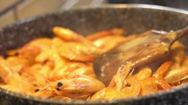 Lezzetli ve iştah açıcı karidesler mutfakta yakın plan bir tavada pişirilir.