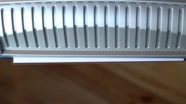 Evdeki kağıtları küçük bir laminatöre doldur. Filmde beyaz bir kağıt parçası cihazdan çıkıyor.