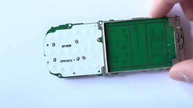 Kiev, Ukrayna - 11 Mart 2021: Beyaz arka planda eski bir düğmeli telefonun elektronik devre kartı