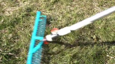 Çimleri kuru otlardan kış sonrası tırmıkla temizleme işlemi.