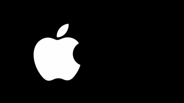 Kiev, Ukraine - 5 avril 2021 : Le logo de la pomme blanche s'illumine dans le sombre gros plan au dos d'un macbook pro — Video