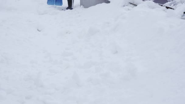 Het gooien van een grote stapel sneeuw met een schop in de avond — Stockvideo