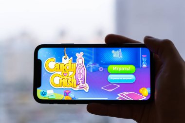Kiev, Ukrayna - 2 Nisan 2021: Candy Crush soda oyunu, şehrin arka planına karşı telefonda açıldı