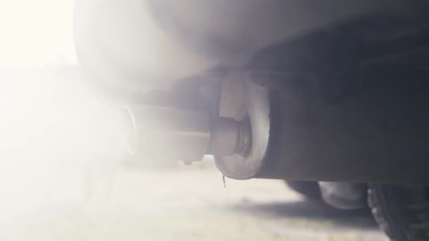Paseo de la cámara alrededor del tubo de escape humeante de humo de un coche — Vídeo de stock