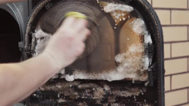 Rozsmarowanie detergentu na ognioodpornym szkle kominka w celu usunięcia osadów węgla — Wideo stockowe