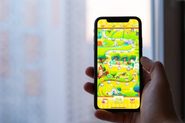 Kiev, Ukrayna - 2 Nisan 2021: Çiftlik kahramanları destanı şehir merkezinin arka planına karşı telefonda açıldı