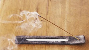 Tütsü çubuğu, hoş kokular ve böcekler için terastaki ahşap bir masada sigara tüttürür.