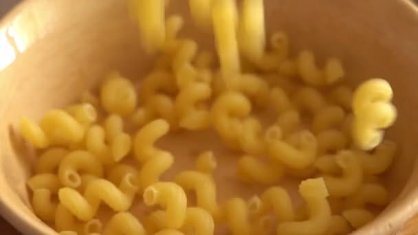 Pasta a forma di spirale che cade in un piatto marrone al rallentatore — Video Stock