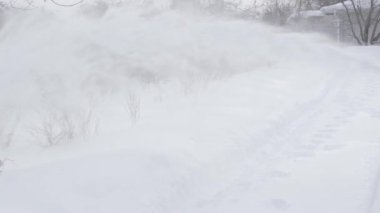 Kar temizleme makinesinin çekme çubuğundan büyük miktarlarda kar püskürtülür.