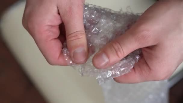 Man wordt nerveus en barst in de bubbel wrap — Stockvideo