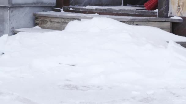 Πετώντας χιόνι από τα σκαλιά στο σπίτι με ένα φτυάρι — Αρχείο Βίντεο