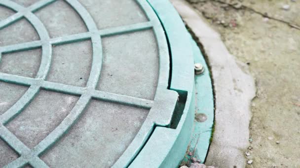 A hand opens a green garden hatch close-up. Water supply well cover — Stock Video