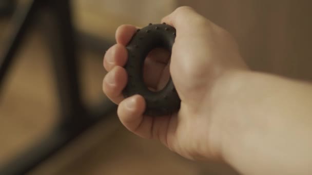 Hand squeezes forearm trainer rubber expander, close-up — Stock Video