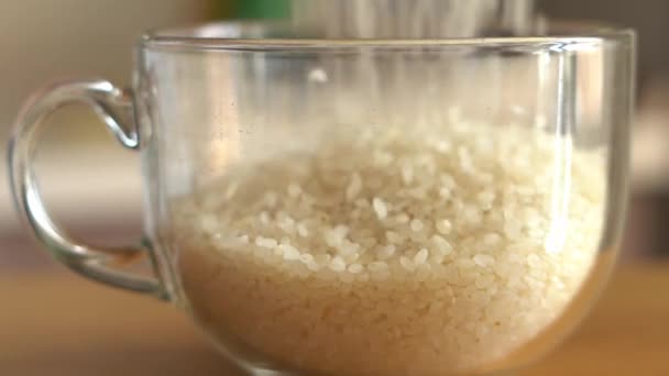 Beyaz pirinç şeffaf cam bardağa düşüyor. Yakın çekim, yavaş çekim. — Stok video