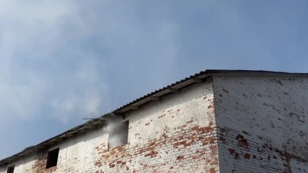 Humo grueso proveniente de la ventana de un viejo edificio abandonado — Vídeos de Stock