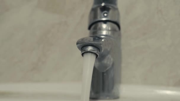 Quadro dinâmico afiado de partida de um close-up de uma torneira aberta com água — Vídeo de Stock