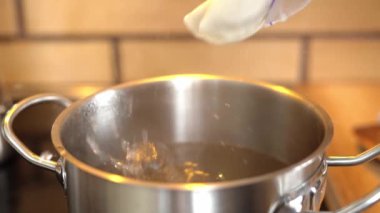 Hamur köftelerini yavaş çekimde sıcak suya atmak.