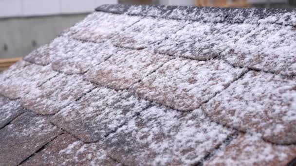 Techo de tejas medio cubierto de nieve,. Nieve cayendo en el techo — Vídeos de Stock