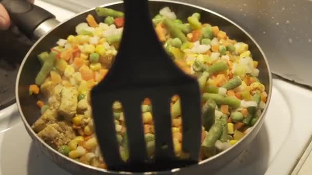 Mezcla de verduras congeladas en una pala de plástico para sartén — Vídeos de Stock