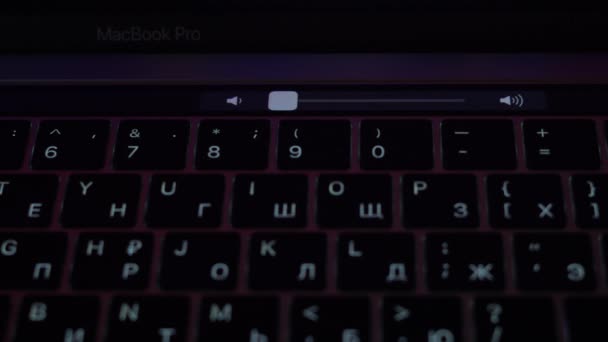 Kiev, Ukraine - April 5, 2021: Increase the volume on a MacBook Pro using the touchbar — стоковое видео