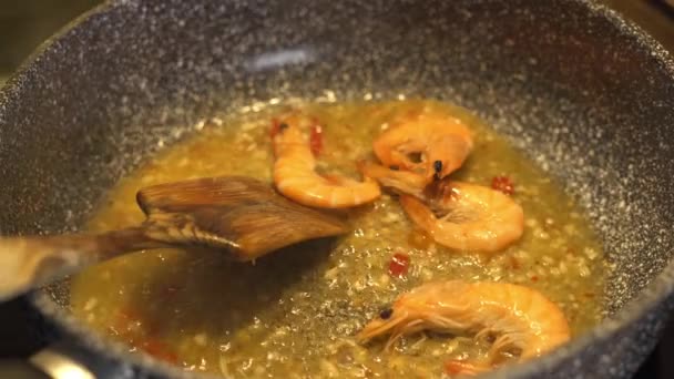 Placing raw shrimp in a hot oil pan — Vídeos de Stock