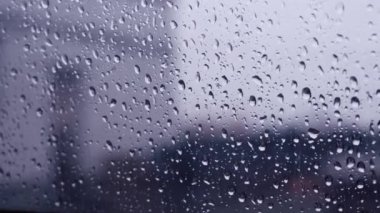 Arabanın renkli camına yakın plan yağmur damlaları. Sallanan kamera