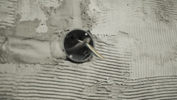 コンクリートの壁にソケットのためのソケットから突き出たワイヤ — ストック動画