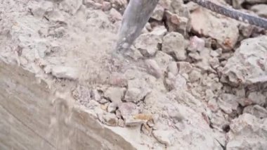 Bir kaya matkabıyla beton bir yapının yıkımından kalan uçan toz ve çipler.