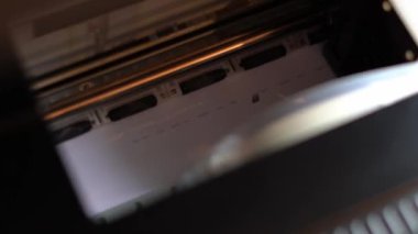 Yazıcı beyaz kağıda siyah yazıyı basıyor.