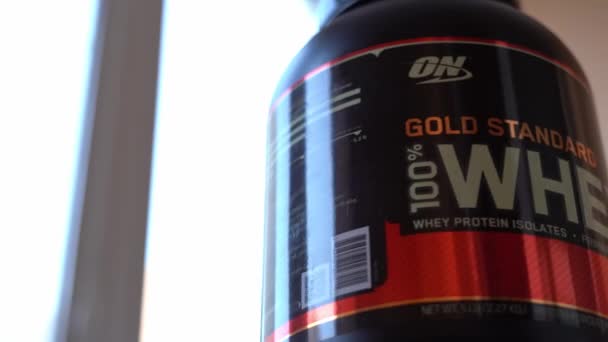 Kiew, Ukraine - 16. Juni 2021: Großes Glas Molkenprotein Goldstandard optimale Ernährung dreht sich in Nahaufnahme — Stockvideo