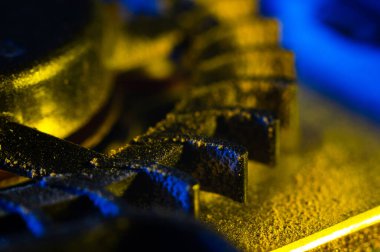 Bir bilgisayar soğutucusunun bıçakları toza yakın çekim. Sarı ışık