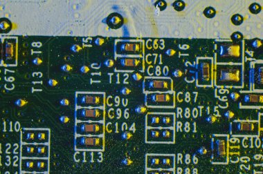 Makro fotoğrafçılıktaki koruyucu bir filmin altındaki elektronik devre kartının yakın çekimi.