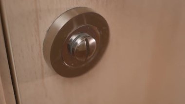 Biri tuvalete girer ve kilidi kapatır, yakın plan. Kapıdaki iç kilidi açıp kapatıyorum. Yüksek kalite 4k görüntü