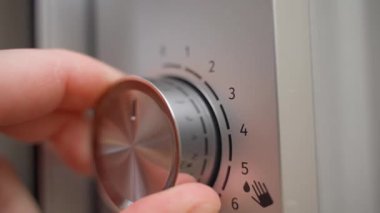 Mikrodalga fırının saatini ayarlıyorum, yakın plan. Yüksek kalite 4k görüntü