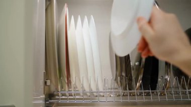 Beyaz tabakları mutfak çekmecesine katlama işlemi, yakın plan. Yüksek kalite 4k görüntü