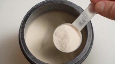 Bir kepçe dolusu toz kolajen alıyorum, yakın plan. Yüksek kalite 4k görüntü