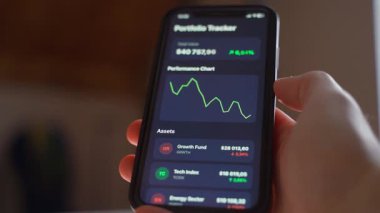 Bir el, düşüşün grafiğini gösteren ve yatırım portföyünün değerini yükselten bir telefonu tutuyor. Yüksek kalite 4k görüntü